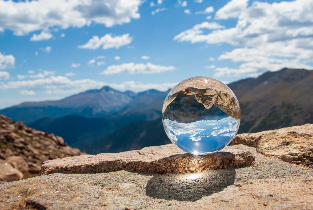 glass ball on mountain top with reflection